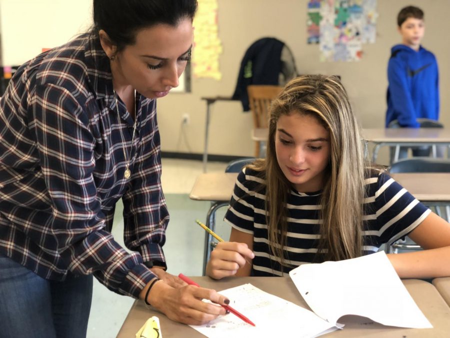 Seventh grade teacher Ms. Christina Thomas looks over a test with a student. 