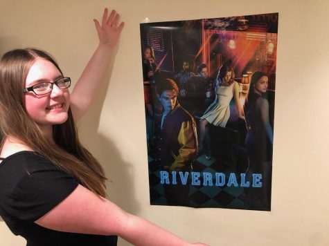 Our Riverdale Reviewer poses before one of her favorite posters of one of her favorite shows.