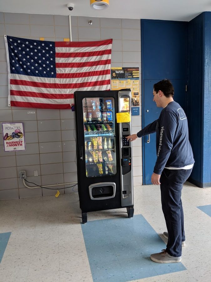 Senior Josh Lind using the the vending machine in the cafeteria to purchase a snack for third period. 