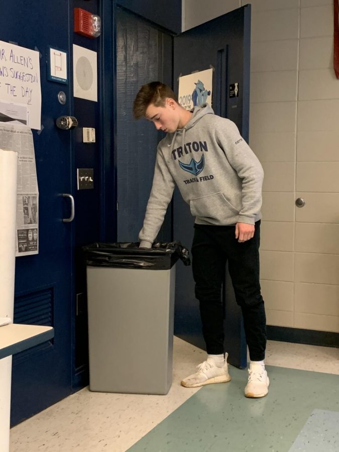 Triton student Derek Cotter throws away an item that had been torn down from a classroom by a student
