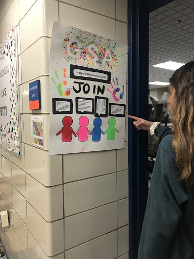 GSA member, Kyla Prussman reads the club’s sign outside Jamie Richard’s classroom (Casaletto photo)