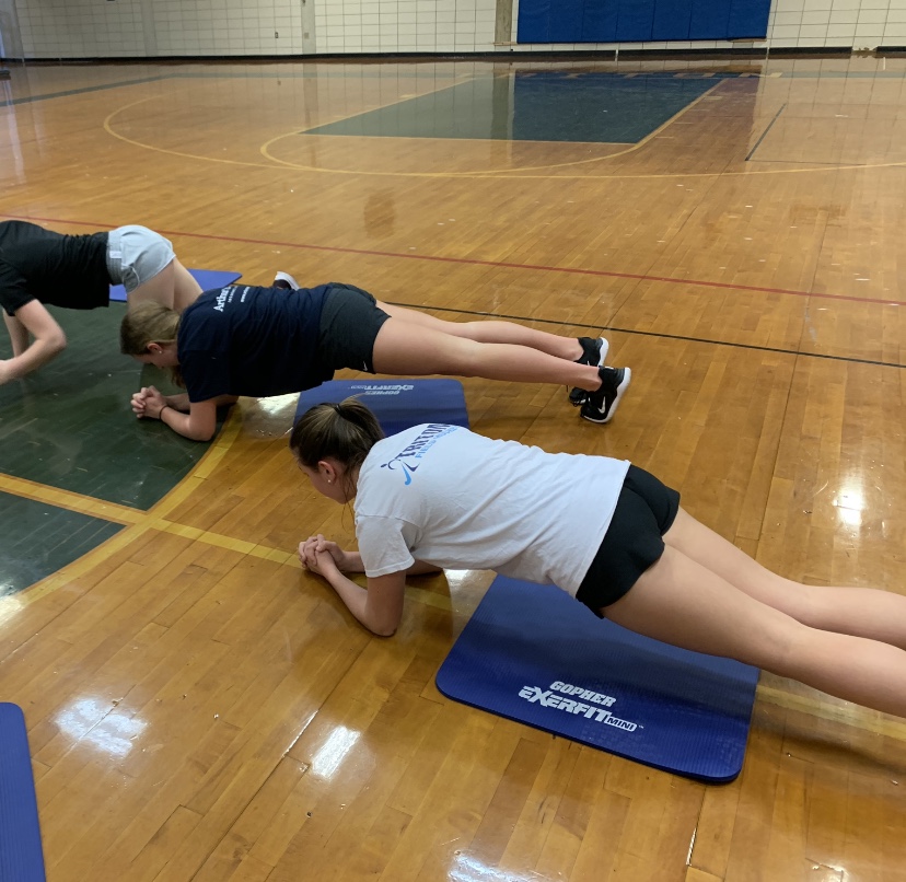 Freshman Chloe Connors and Ally Pugh doing a core workout to get ready for their upcoming lacrosse season 