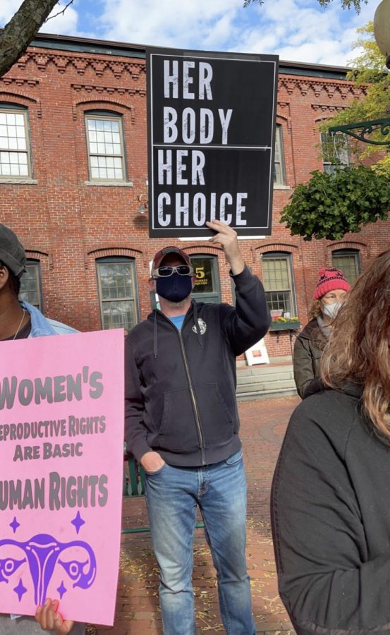 Matt Johnston stands with a Her Body, Her Choice sign in Amesbury, Massachusetts during the march last month for abortion rights.