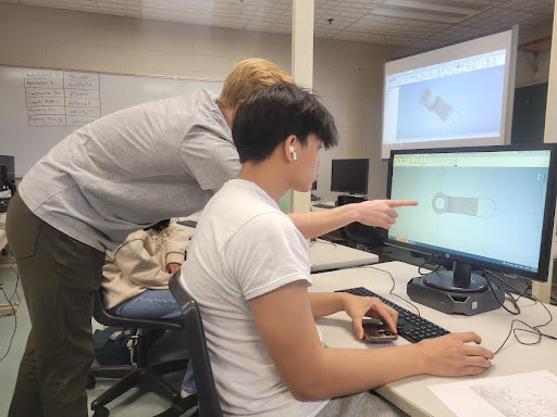 Teacher Mathew Guerin helping student Jason Ly with his project
