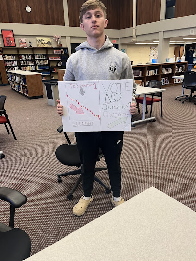 Senior Jakob Lennon holds a poster representing his  groups topic (Photo: Nate Eaton)
