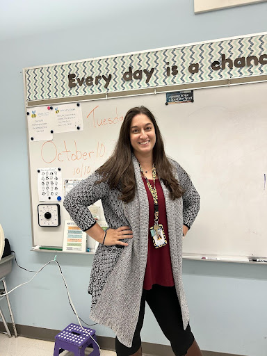 New teacher, Lebrun, poses in front of her whiteboard in her classroom.