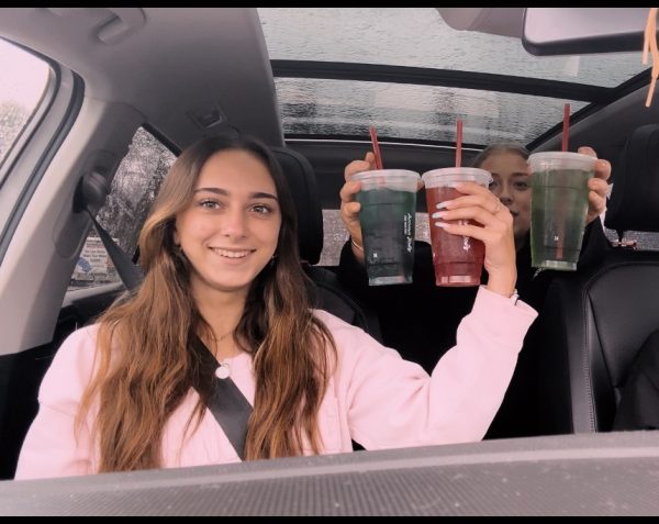 ashley sabino holding up the three drinks tried by triton voice writers.