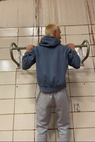 Beckham Zizza is doing pull-ups to train his upper body strength.

