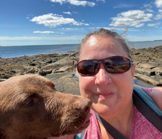Ms. Christine DeNuzzio poses on the Maine coast with her pup this summer 