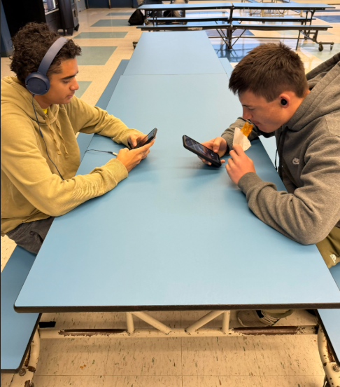 Two juniors with their phones hang out during lunch, the only extended time during the school day when the devices are permitted.