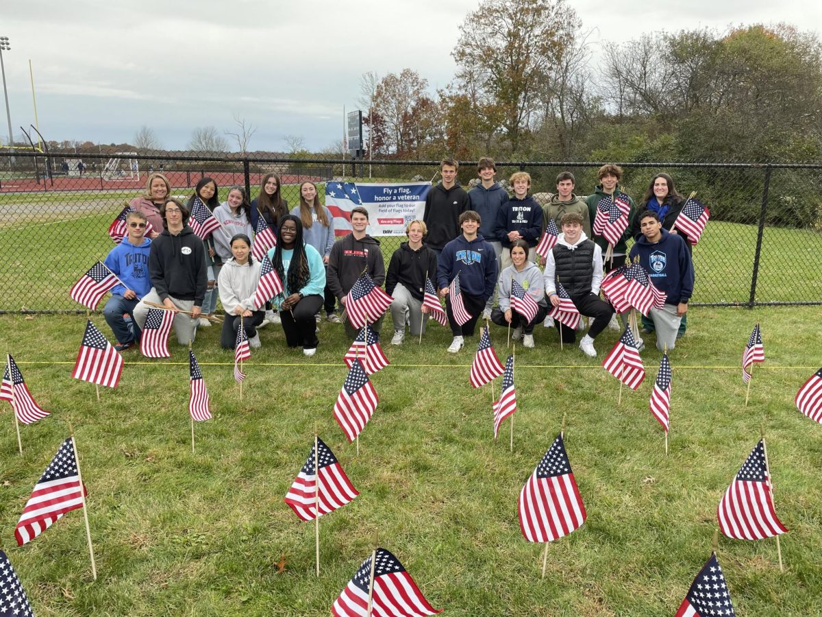Student members of the community service club place flags near the front of the school ceromonies in 2024