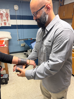 Triton High School trainer Mike Ruzyky tapes an athlete's wrist before a match.